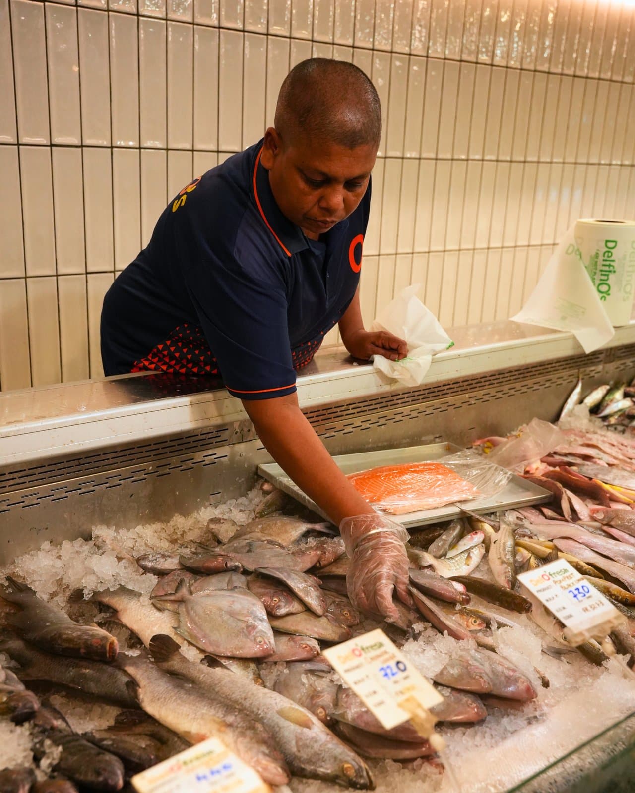 A Delfino's team member laying out the day's fish on ice