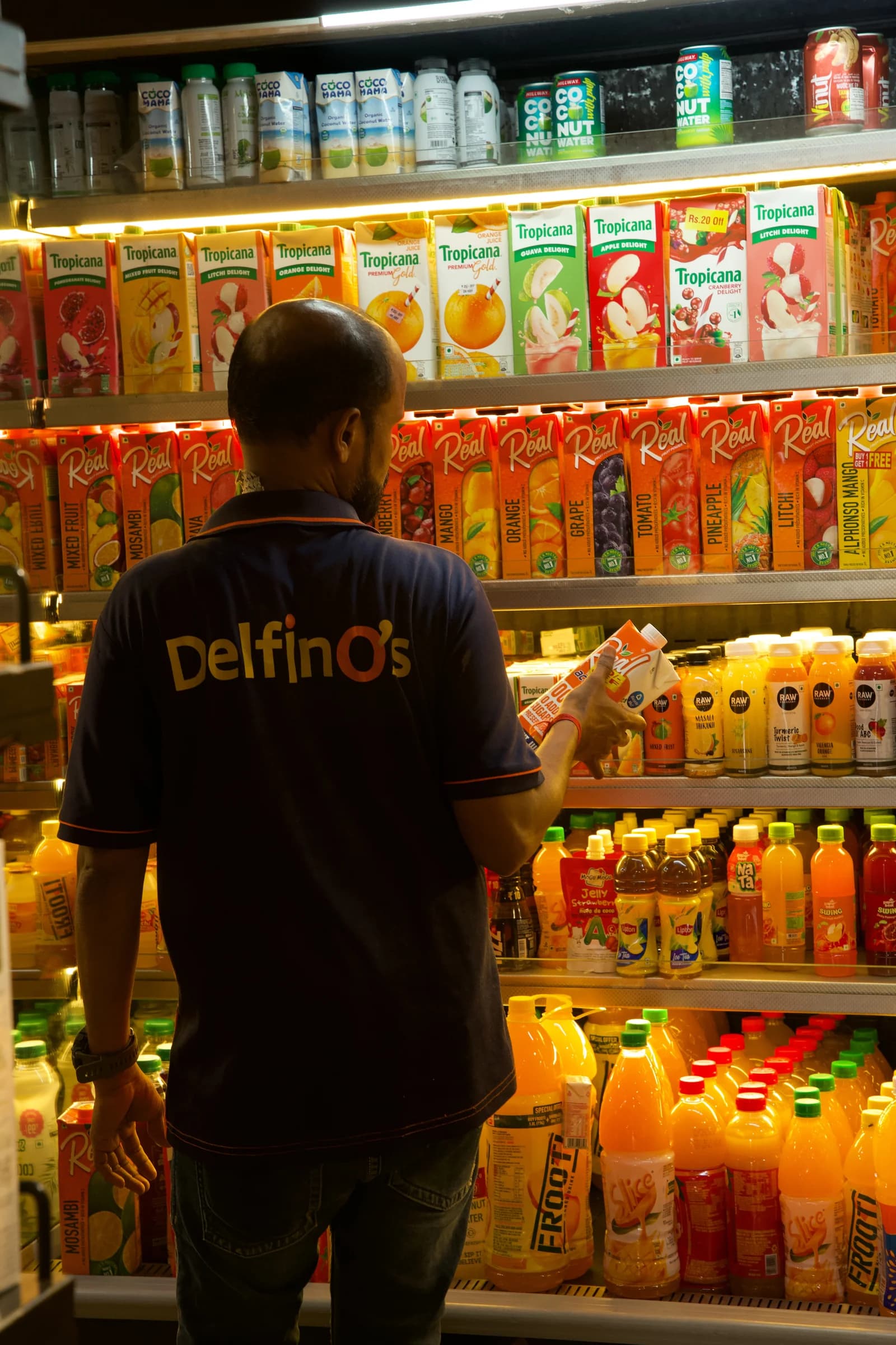 A Delfino's team member stocking the soft drinks