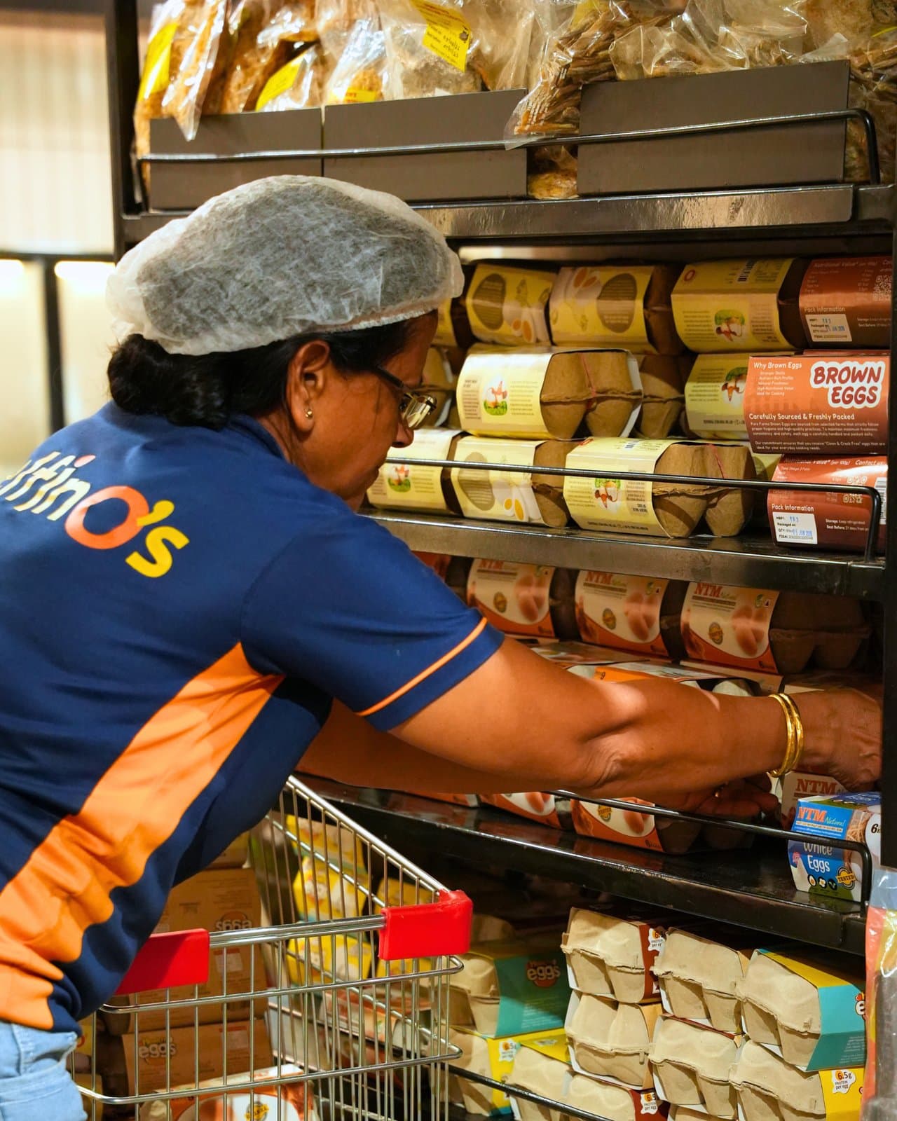A Delfino's team member stocking the egg shelves