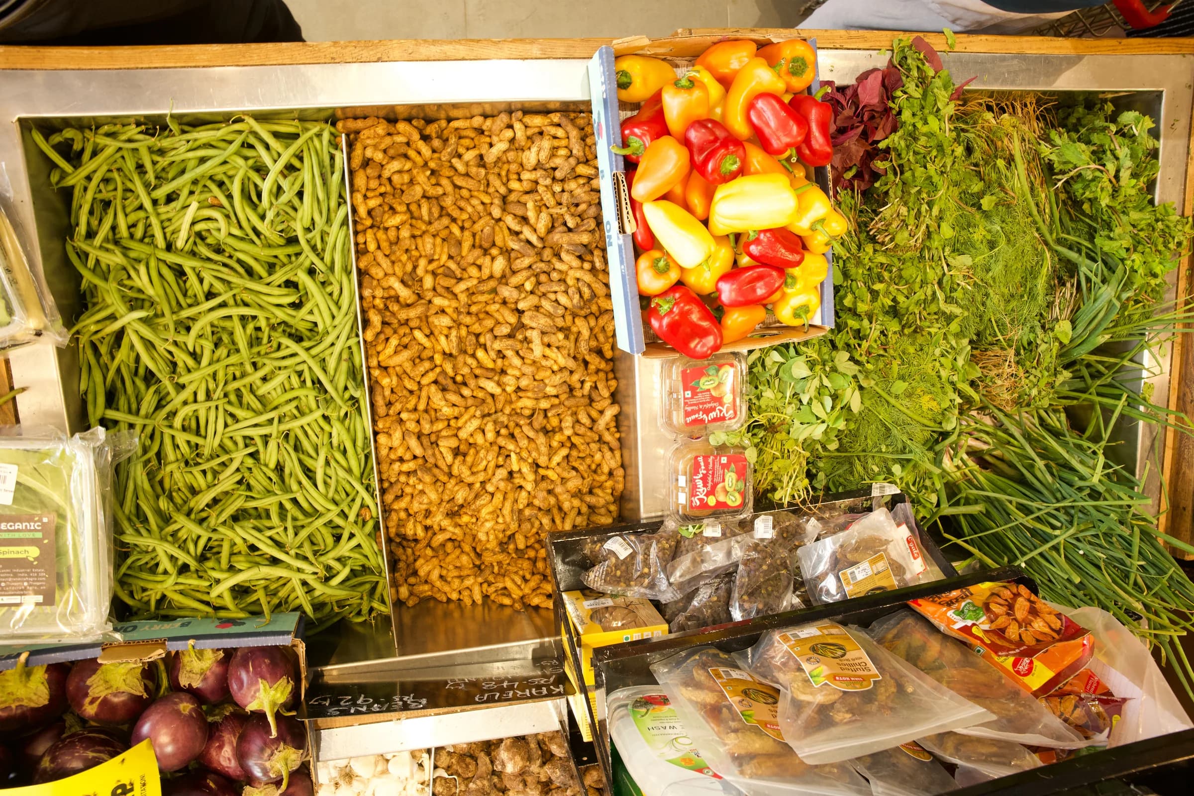 Fresh vegetables and herbs arranged across the produce counter